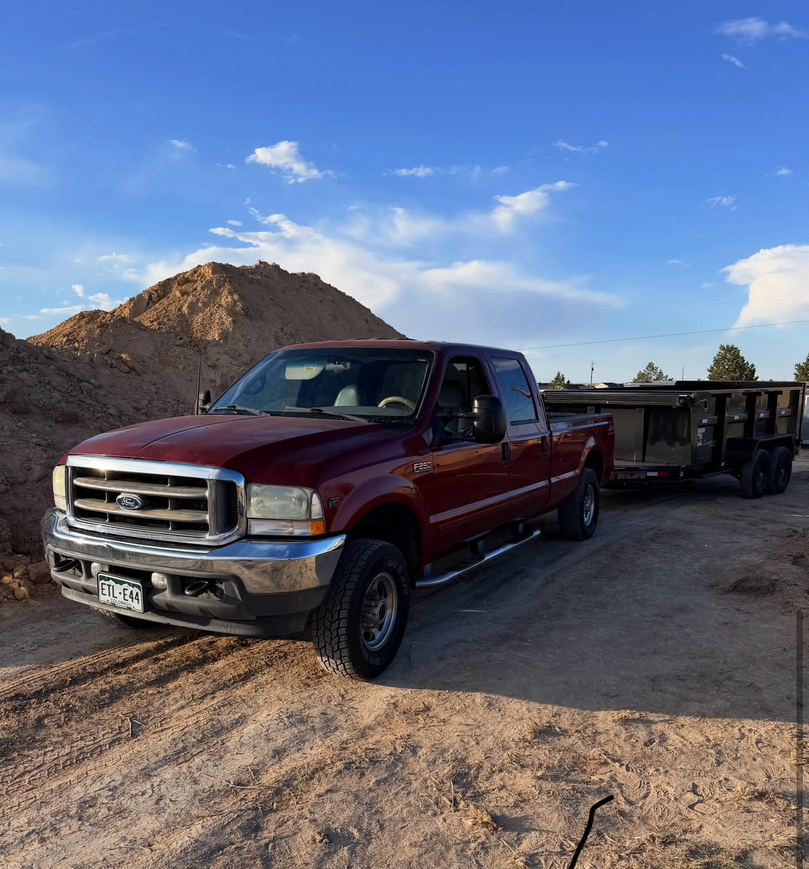 Rhinos Junk and Material Hauling truck with dump trailer at a Colorado job site